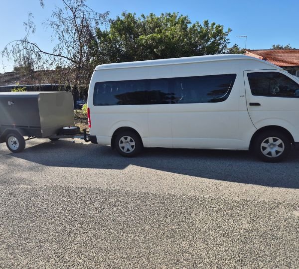 White 12-seater minibus with a luggage trailer attached for group travel in Perth